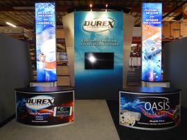 RENTAL: Modified RE-9084 Island Design with 15 ft. High Graphic Tower with Arch Canopy and Frosted Acrylic Accent Wings, (2) 15 ft. High Double-Sided Lightbox Kiosks with RE-1202 Rectangular Counters, (2) RE-1205 Large Curved Counters, 60 in. Monitor, and